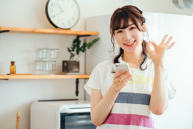 スマートフォンで挨拶する笑顔の女性