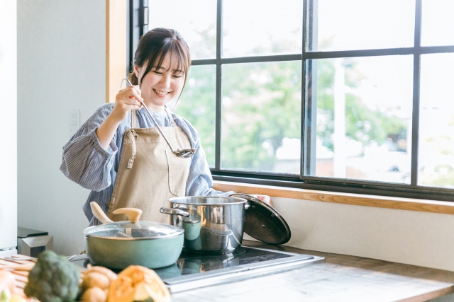 明るいキッチンで料理をする女性